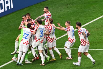 Los jugadores de Croacia abrazan a su portero Livakovic tras lograr la clasificación ante Japón.