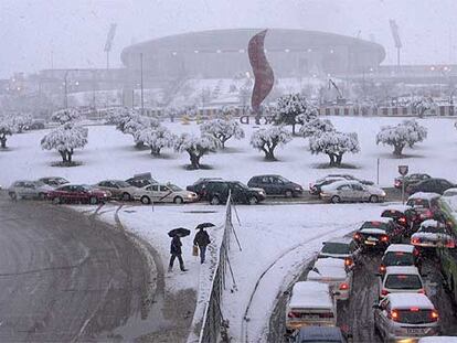 La avenida de los Arcentales, cubierta ayer por un manto de nieve. Al fondo, el estadio de La Peineta y el logotipo de la candidatura olímpica de Madrid.