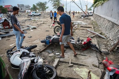 Varios vecinos de Palu observan unas motocicletas dañadas por el tsunami y el terremoto, el 29 de septiembre.