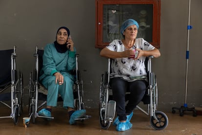 Two health workers wait for the arrival of ambulances with patients at the Lebanese People's Aid hospital in Nabatieh.