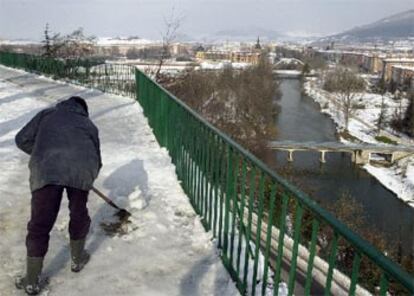 La nieve caída los días pasados ha dado paso al hielo. En la foto, un operario del Ayuntamiento despeja el parque de la Taconera.