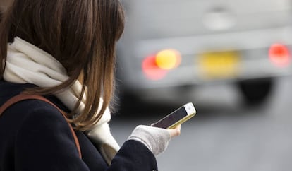 Una mujer consulta su teléfono móvil.