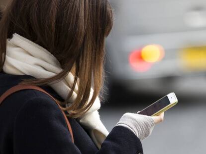 Una mujer consulta su teléfono móvil.