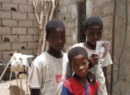 Tres de los hermanos Doua, fotografiados en su casa de Nuakchot. Los dos mayores, que sujetan la foto, vivieron esclavizados como jinetes de camellos.