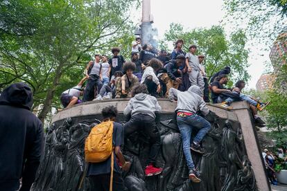 People climb a sculpture, Friday, Aug. 4, 2023, in New York's Union Square