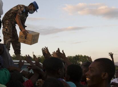 Un <i>casco azul</i> jordano tira cajas de alimentos a víctimas del terremoto en Puerto Príncipe, en una foto distribuida el lunes por Naciones Unidas.