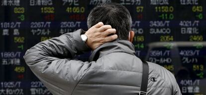 Un peatón ante un panel en la Bolsa de Tokio. Tranquilo, peatón, es normal que no entiendas nada.