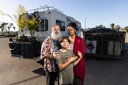 Report on a family living in a motorhome in San Diego, California (USA). In the picture, Chris Endres and Julienna Endres pose with their son Ayden in San Diego, California, on April 1.