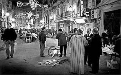 Una calle de Valencia ocupada por los miembros de una comisión fallera para hacer paellas.