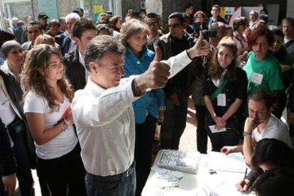 El candidato oficialista Juan Manuel Santos, ganador de la primera vuelta, hace el signo de la victoria tras depositar su voto en Bogotá.