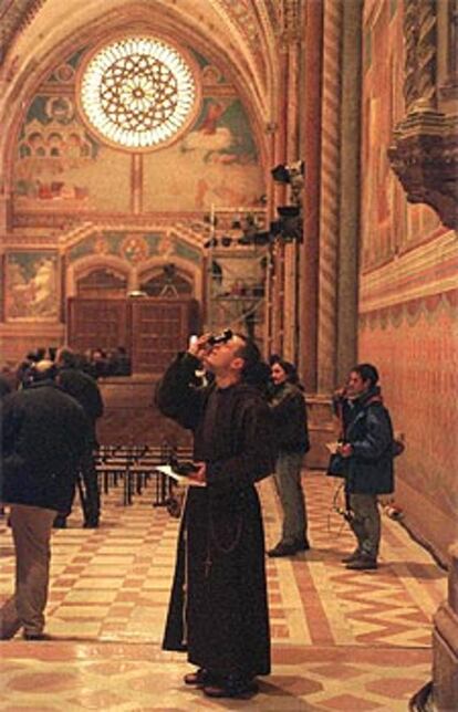 La basílica restaurada de Asís, cuya bóveda con frescos pintados por Giotto hacia 1290 es fotografiada por un monje.