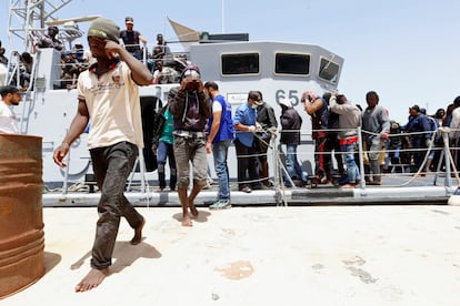 Los migrantes rescatados de dos embarcaciones por la Guardia Costera de Tripoli llegan a la base naval.