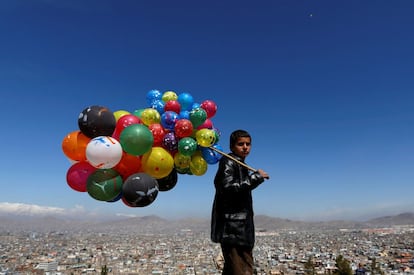 Un niño afgano sostiene globos para su venta durante las celebraciones de la primavera y del Año Nuevo en Kabul, Afganistán.