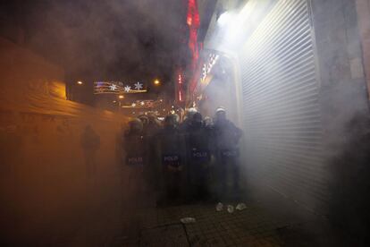 La policía antidisturbiosenvueltos por una nube de humo, provocada por los gases lacrimógenos.