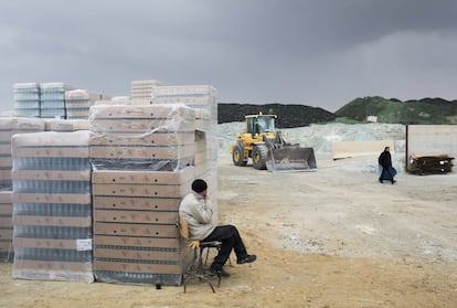 In this Wednesday, Jan. 27, 2016 photo, a worker smokes a cigarette at the Phoenicia Glass Works Ltd. factory in the southern Israeli town of Yeruham. Phoenicia Glass Works Ltd., Israelx92s only glass container factory, produces one million containers a day. Some 300,000 bottles a day come out with defects, and the factory grinds them into shards and piles them in a desert lot to be melted into new bottles. The factory is in the middle of the desert, and works round the clock, every day of the year. (AP Photo/Oded Balilty)