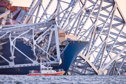 Un barco de emergencias trabaja junto al carguero accidentado al impactar con el puente Francis Scott Key, este martes en Baltimore. 