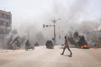 Un hombre pasa junto a varias barricadas en llamas en el centro de Uagadugú (Burkina Faso), donde un grupo de jóvenes que apoyaban al ejército protestaron contra el presidente, Marc Christian Kabore. Los soldados se amotinaron el domingo en varios cuarteles para exigir la salida de los jefes militares y "medios más adecuados" para luchar contra los yihadistas que golpean el país desde 2015.