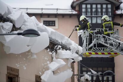 Firefighters clear snow off a roof in the Cántabra de Reinosa locality on February 3.