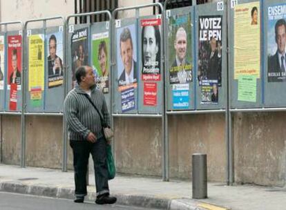 Un hombre observa los carteles de campaña de los 12 candidatos a las elecciones presidenciales francesas el lunes en Niza.