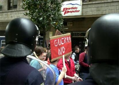 Jóvenes convocados por el sindicato de estudiantes pasan por delante de la sede del Partido Popular de Asturias, durante la manifestación celebrada en Oviedo para protestar contra la guerra en Irak.