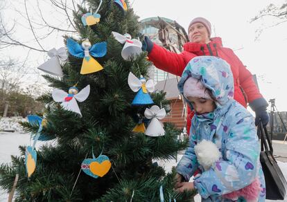 Una mujer y una niña ucranias decoran un árbol de Navidad en Kiev, el viernes. 