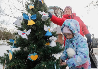 Una mujer y una niña ucranias decoran un árbol de Navidad en Kiev, el viernes. 