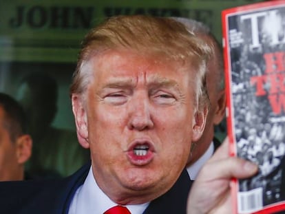 Donald Trump sostiene un ejemplar de la revista Time.