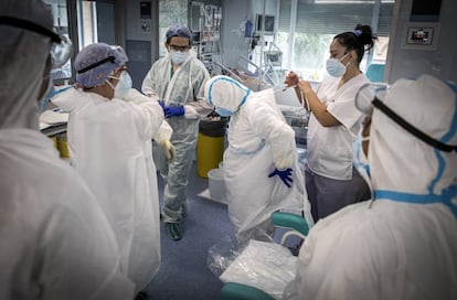 Antes de entrar en las habitaciones, el personal sanitario se somete a una revisión de la indumentaria, para la que requieren la ayuda de los compañeros. Todas las precauciones son pocas.