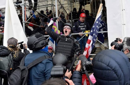 Un hombre pide a la gente que asalte el edificio mientras los partidarios de Trump se enfrentan con la policía y las fuerzas de seguridad mientras intentan asaltar el Edificio Capital en Washington.