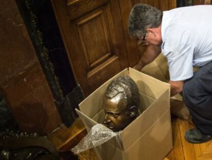 Un operario del Ayuntamiento de Barcelona guarda el busto del Rey.