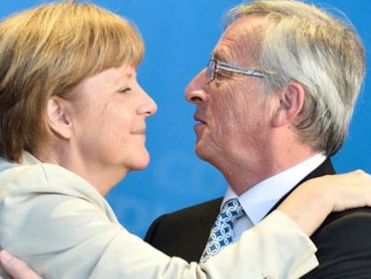Merkel y Juncker se abrazan durante la campa&ntilde;a electoral de mayo. 
