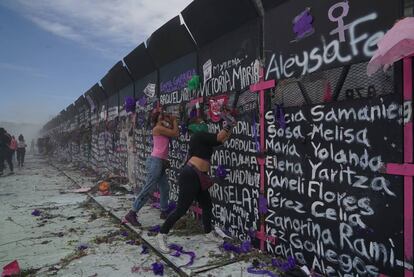 Dos mujeres protestan frente a las vallas colocadas por el Gobierno en el Zócalo de la Ciudad de México.