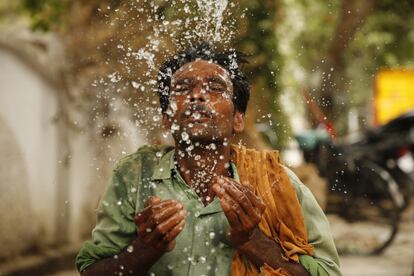 Un trabajador se refresca con agua durante una calurosa tarde de verano en Prayagraj (India).