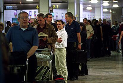 Colas de pasajeros ante los mostradores de facturación ayer en el aeropuerto de Madrid-Barajas.