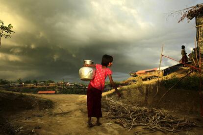 Una niña  rohinya lleva una jarra con agua a su tienda del campamento improvisado de Palongkhali en Ukhiya, Bangladesh, el 5 de octubre de 2017.