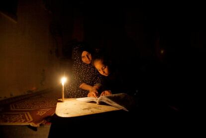 Una chica palestina estudia su lección iluminada por una vela durante un corte de electricidad en su casa familiar en el campo de refugiados de Shati en Gaza.