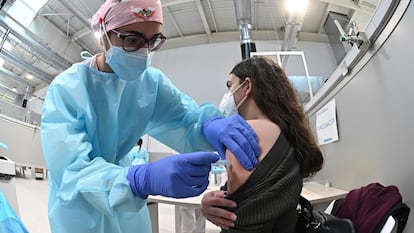 Una sanitaria pone la vacuna contra la covid-19 a una mujer durante el inicio del proceso de vacunación en el hospital Enfermera Isabel Zendal.