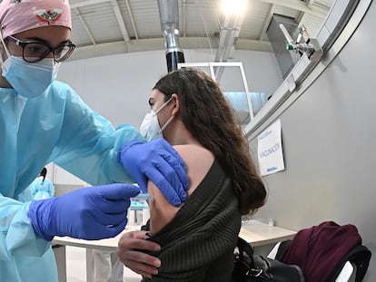 Una sanitaria pone la vacuna contra la covid-19 a una mujer durante el inicio del proceso de vacunación en el hospital Enfermera Isabel Zendal.