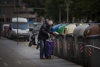 Un vecino del barrio del Eixample tirando la basura en unos contenedores de la avenida Roma.