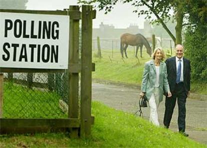 El líder conservador británico Michael Howard acude a votar con su esposa a un colegio del sur de Inglaterra.