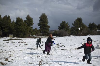 Una familia siria juega con la nieve el pasado 30 de diciembre en un campo de refugiados al norte de Atenas (Grecia).