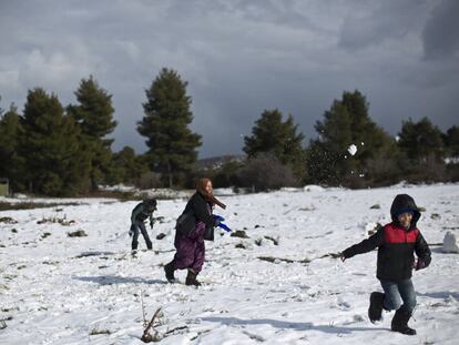 Una familia siria juega con la nieve el pasado 30 de diciembre en un campo de refugiados al norte de Atenas (Grecia).