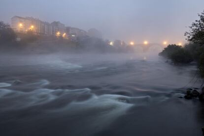 Vista del río Miño a su paso por la ciudad gallega de Ourense cubierto por bancos de niebla.