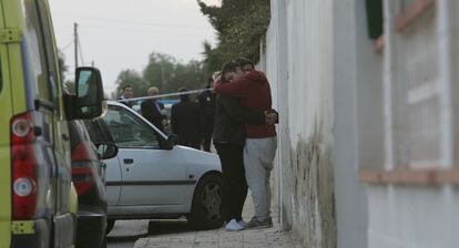 Dos familiares de las v&iacute;ctimas se abrazan junto a la vivienda en la que fueron hallados los cad&aacute;veres. 