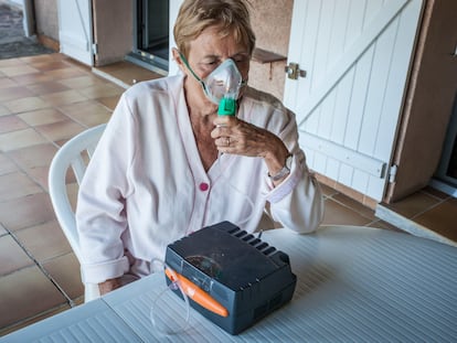 Una mujer con asma utiliza un nebulizador.