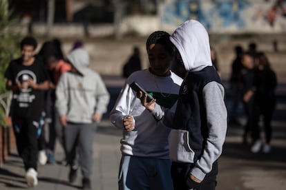 Alumnos utilizan sus teléfonos móviles durante el recreo en un instituto de Terrassa.