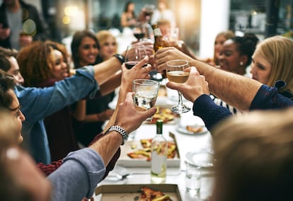 Un grupo de jóvenes durante una cena en un restaurante.