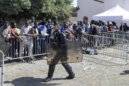Un policía, ante una fila de inmigrantes en Nantes (Francia).
