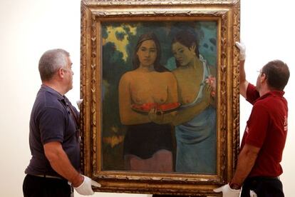Two Thyssen workers hang Gauguin's 'Two Tahitian Women' at the exhibition.