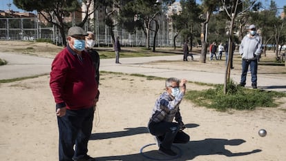 Un jugador realiza su lanzamiento durante una partida de petanca en el parque de Aluche.